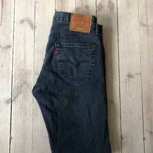 Levi's 501 jeans i mörkblå denim - Säljer ett par klassiska Levi's 501 jeans i mörkblå denim. De har en rak passform. Perfekta för en tidlös stil. Jeansens ikoniska design inkluderar den röda Levi's-loggan och en läderpatch baktill.