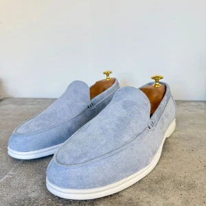 Ljusblå loafers i mocka - Snygga ljusblå loafers i mocka med en stilren design. Skorna har en vit sula som ger en fräsch kontrast. Perfekta för en avslappnad men ändå elegant look. Unbranded köpta i Frankrike nypris 900kr mitt pris 499kr