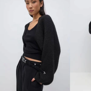 Svart stickad kofta - Säljer en svart stickad bolero med långa ärmar. Perfekt för kyligare dagar och enkel att matcha med olika outfits. Koftan har en lös passform och är supermysig att ha på sig.