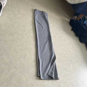 Ljusgrå kjol med sprund bak - Snygg ljusgrå vadlång  kjol  från märket Lager 157  i storlek XS. Kjolen  har en stilren design och är perfekta för en minimalistisk look. De är tillverkade i ett mjukt material som ger en bekväm passform.Poyester tror jag. knappt använda.