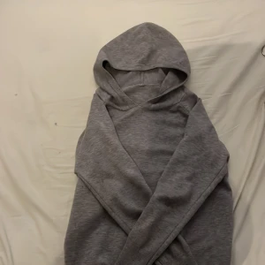 Grå hoodie HM  - Säljer en stilren grå hoodie med långa ärmar och en klassisk huva. Perfekt för en avslappnad look. Passar både till vardags och för en mysig hemmakväll.