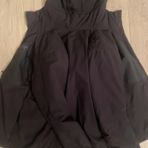 Svart jacka från Arc'teryx - Säljer en svart jacka från Arc'teryx. Jackan har en stilren design med dragkedja och är perfekt för vår, höst och mildare vintrar. Den är tillverkad i ett slitstarkt material och har en bekväm passform. (Nypris 3000) knappt använd, priset kan verkligen diskutera vid snabb affär
