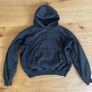 Svart hoodie från YZY - Säljer en svart hoodie från YZY med en klassisk design. Den har en stor ficka framtill och en rymlig huva. Perfekt för en avslappnad stil. Passar bra till både jeans och joggers. YZY GAP hoodie looks small but fit well