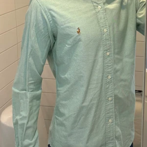 Polo Ralph Lauren skjorta - Säljer denna extremt stiliga skjorta från Polo Ralph Lauren. Tröjan är i riktigt fint skick 10/10 för ett väldigt bra pris. Färgen är turkos/ljusblå. Bara att höra av sig vid minsta fundering!