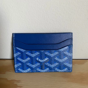 Blå plånbok med mönster - Snygg blå plånbok med ett unikt mönster och flera fack för kort. Perfekt för att hålla ordning på dina kort och kontanter med stil.