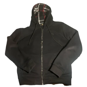 Burberry zip hoodie - Skit snygg svart burberry hoodie i väldigt bra skick. Tröjan är i storlek L men den passar mer som M. Tveka inte att höra av dig vid frågor! Pris går att diskutera!