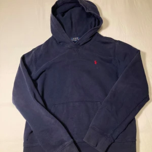 Polo Ralph Lauren Hoodie - Säljer en snygg mörkblå hoodie från Polo Ralph Lauren i storlek 14-16/XS. Tröjan är stilren och kan matcha med allt. Jag står ej för PostNords eller instabox strul. Vid snabb affär kan priset diskuteras! 