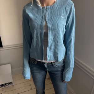 Ljusblå ribbad kofta från Karl Lagerfeld - Säljer en  ljusblå ribbad kofta från Karl Lagerfeld i nyskick. Lappar fortfarande kvar! Koftan har långa ärmar och en diskret logga broderad på bröstet. Perfekt för en elegant och avslappnad look. Hör av dig vid intresse! 💙