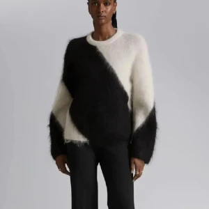 Svart och vit mohairtröja - Säljer en stilren och fluffig mohairtröja i svart och vitt med ett diagonalt mönster. Tröjan har långa ärmar och en rund halsringning, från &other stories