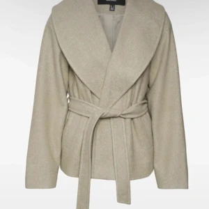 Beige kappa med knytband - Säljer en superfin beige kappa med knytband i midjan. Perfekt för höst och vår! Den har en omlott-design och långa ärmar, vilket ger en elegant look. Passar både till vardags och fest. 🧥✨ Från vero moda