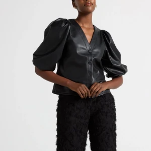 Svart skinnblus med puffärmar - Snygg svart blus i skinnimitation med puffiga trekvartsärmar och knappar framtill. Endast använd 1 gång❣️