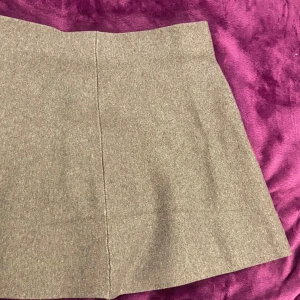 Beige kjol från Gina Tricot - Snygg kjol från Gina Tricot i en klassisk och stilren design. Kjolen har en rak passform och är perfekt för en chic look. Tillverkad i ett mjukt material som ger en bekväm känsla hela dagen.