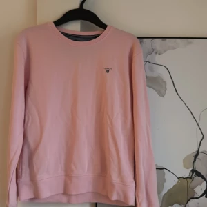 Rosa tröja från GANT - Xs/ 170 barnstorlek, Säljer en stilren rosa tröja från GANT med rund hals och broderad logotyp på bröstet. Perfekt för en avslappnad look.