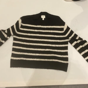 Svart och vit randig tröja från H&M - Säljer en svart och vit randig tröja från H&M. Tröjan har långa ärmar och är perfekt för en stilren look. Den är gjord i ett mjukt material som känns skönt mot huden.