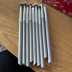 Set med sminkborstar i silver - Säljer ett set med åtta sminkborstar i silverfärg. Borstarna har mjuka borst och är perfekta för att applicera ögonskugga. Handtagen är släta och eleganta, vilket ger ett lyxigt intryck. Ifrån märket Flaer