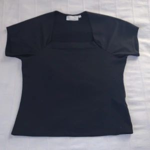 Svart elastisk topp med fyrkantig urringning - 38/40 - Skitsnygg elastisk topp med fyrkantig urringning. Storlek 38/40 och i fint skick. 