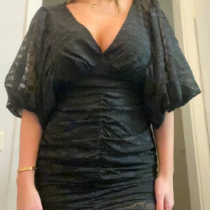 Svart klänning med puffärmar - Fin svart klänning med v-ringning och puffiga ärmar.. perfekt för nyår