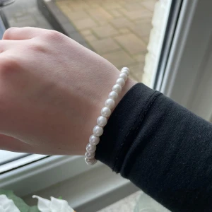 Vitt pärlarmband - Elegant vitt pärlarmband med klassiska runda pärlor. Perfekt för att ge en sofistikerad touch till din outfit. Armbandet är elastiskt och passar de flesta handleder. Man får båda armbanden!