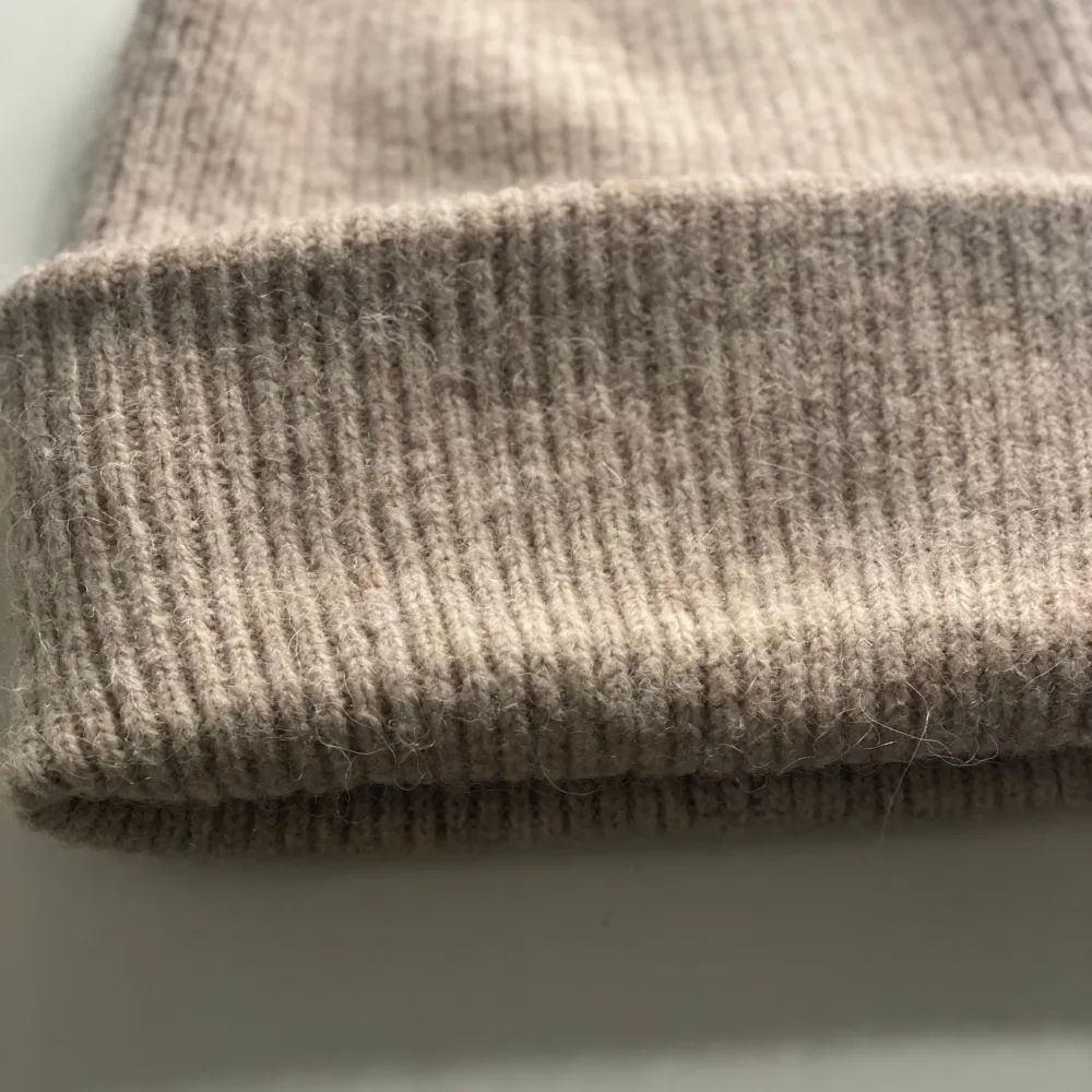 Säljer en mysig beige stickad mössa från Kappahl. Perfekt för kyliga dagar med sin ribbade design som ger extra värme och stil. Passar alla tack vare one size-storleken.. Asusteet.
