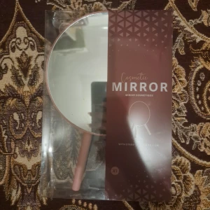 Kosmetisk spegel med handtag - Elegant kosmetisk spegel med ett stilrent handtag. Perfekt för sminkrutinen och enkel att använda. Spegeln har en rund form och kommer i en snygg förpackning.