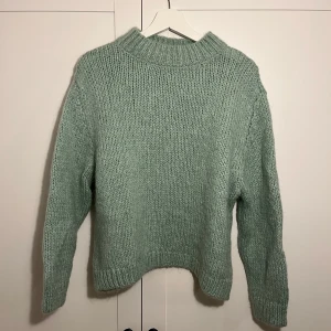Grön stickad tröja från Zara - Mysig grön stickad tröja från Zara med långa ärmar och ribbade kanter. Perfekt för kyliga dagar och ger en avslappnad stil.