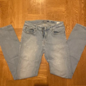 Ljusblå jeans från Dressmann - Säljer ett par ljusblå jeans från Dressmann. De har en klassisk femficksdesign, riktigt grisch och laidback. Perfekta för en avslappnad stil. Galet bra till vinter och vår