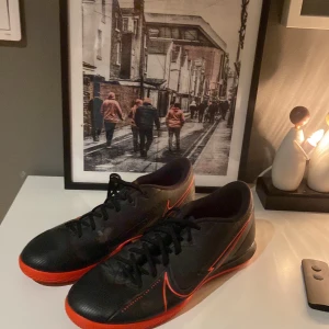 Nike Futsal skor ST. 42,5 - Snygga svarta Nike futsal skor med röda detaljer och sula. Inte ens använda en säsong, sparsamt använda nästan ny skick utom avskavd färg på insidan av fötterna. Perfekt till fotboll på vinter tid.!