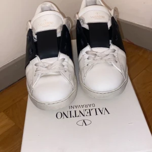 Valentino Garavani  - Snygga Valentino Garavani sneakers i vitt med svarta detaljer. Skorna är använda och är köpta på plick.