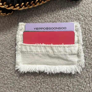 Vit korthållare med fransar - 018 - Säljer en stilren vit kortficka med fransar runt kanterna. Perfekt för att hålla dina kort organiserade. Enkel och praktisk design. Betalning sker via swish