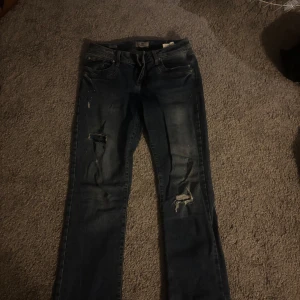 Mörkblå jeans med slitningar - Säljer ett par mörkblå jeans från Levis med coola slitningar på framsidan. 