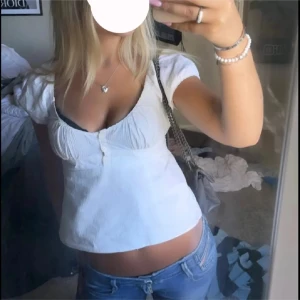 Vit kortärmad topp - Säljer en söt vit kortärmad topp med knappar framtill från brandy melville. Köpt här på Plick med aldrig använd. 