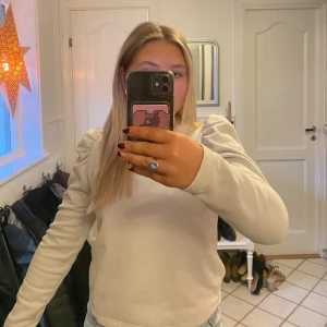 Beige tröja med puffärmar från Zara - Säljer en stilren beige/ljusgrå tröja från Zara med puffiga långa ärmar.  Säljer då den inte kommer till användning och är normal i storlek. Passar lika bra till vardag som till kalas/festligheter!!