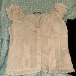 Rosa blus  - Säljer en  rosa  blus med volangdetaljer och knappar framtill. Oanvänd!