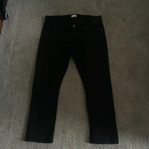 Svarta jeans från Bläck - Säljer ett par snygga svarta jeans från Bläck i storlek 54. De har en klassisk femficksdesign och är perfekta för både vardag och fest. Jeansen är i bra skick och har en stilren look som passar till det mesta. Perfekt för dig som vill ha ett par stilrena och bekväma byxor!