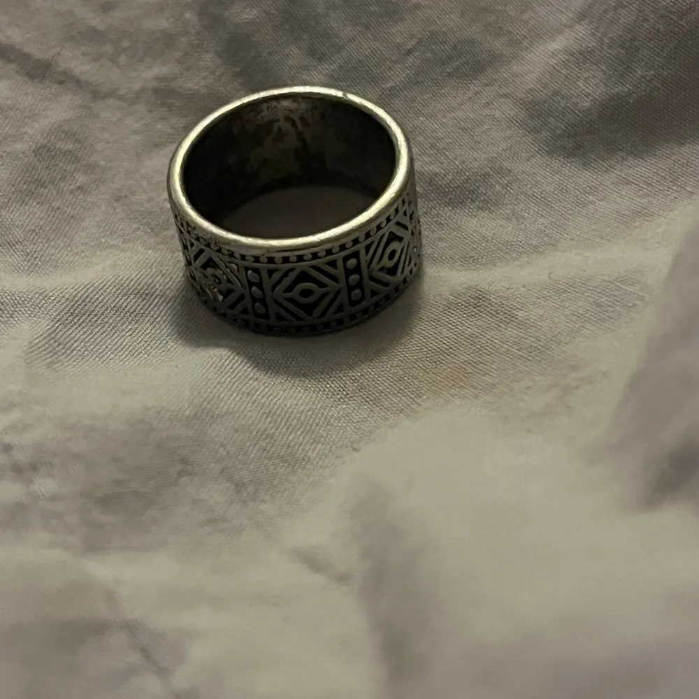 Säljer en cool silverfärgad ring med ett unikt geometriskt mönster runtom. Perfekt för att ge din outfit en edgy touch. Ringen är i bra skick och passar de flesta tillfällen. Perfekt för både vardag och fest!. Accessoarer.