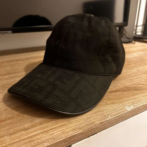 Fendi keps  - Säljer en stilren svart keps med ett diskret mönster. Kepsen har en justerbar rem baktill för perfekt passform. Perfekt för alla tillfällen. Pris går att diskutera!
