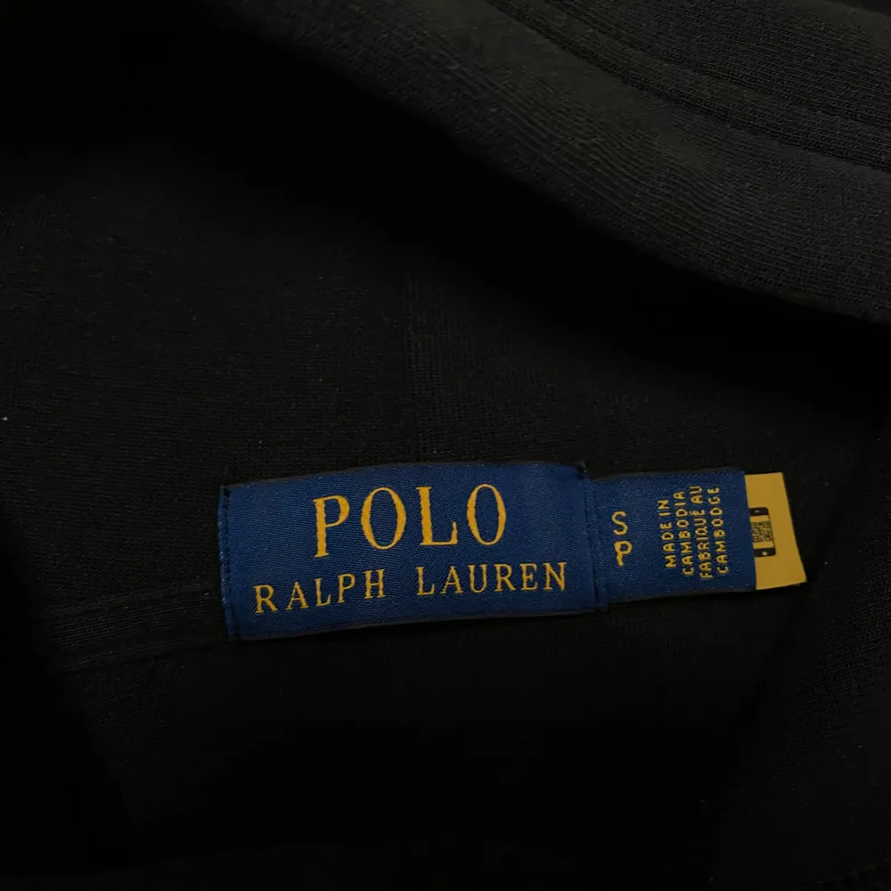 Säljer en stilren svart hoodie från Polo Ralph Lauren. Storlek S. Den har en klassisk design med en vit Ralph Lauren logga på bröstet. Perfekt nu inför Höst o vinter🍂 Passar till allt och är väldigt bekväm.🖤 Tröjan är använd fåtal gånger och är därför i helt Nyskick. Köpt på Ralph laurens hemsida för 2295 kr. Skriv för frågor. Priset ej hugget i sten.. Hoodies.