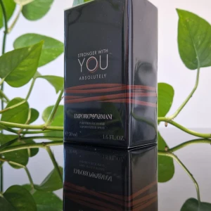 Stronger With You Absolutely från Emporio Armani - Säljer en elegant parfym, Stronger With You Absolutely, från Emporio Armani. Flaskan är stilren och svart med subtila röda detaljer. Den rymmer 50 ml av en intensiv och förförisk doft som passar perfekt för speciella tillfällen. Den är helt ny.