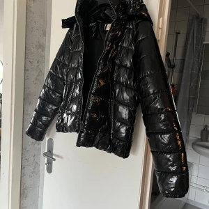 Glansig jacka  - Jättefin populär glansig jacka ifrån Nelly, använd bara under en vinter så nästan som ny. Inget som är sönder eller så heller. 