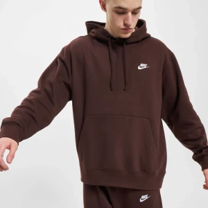 Brun hoodie från Nike - Säljer en snygg och bekväm brun hoodie från Nike. Den har en klassisk design med en känguruficka och justerbar huva. Perfekt för både chill och vardagsbruk. Nike-loggan är broderad i vitt på bröstet. Passar perfekt till höst och vinter!