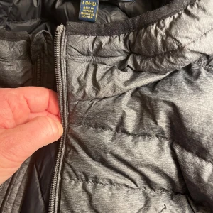 Dunjacka Polo Ralph Lauren strlk L (14-16år), grå - Tunn superlätt dunjacka i jätte fint skick. För lite för sonen så säljer vidare. Storlek L, barnstorlek. Inget slitage eller synliga fläckar. Från djur- och rökfritt hem.  Pris kan diskuteras! Hör av dig!