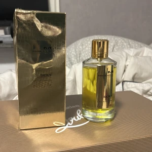 Sicily parfym från Mancera - Säljer en lyxig parfym från Mancera, modellen Sicily. Flaskan är elegant med en gyllene kork och klar glasflaska som visar den gula vätskan. Förpackningen är i glänsande guld, vilket ger en exklusiv känsla. Perfekt för den som vill ha en doft som sticker ut! 120 ml pris diskuteras