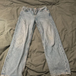 Blå jeans  - Säljer ett par blå högmidjade jeans. Väl använda men i bra skick. Har en fläck på benet som inte går bort. De är även slitna i byxkanten då de varit lite för långa för mig. Nypris 599