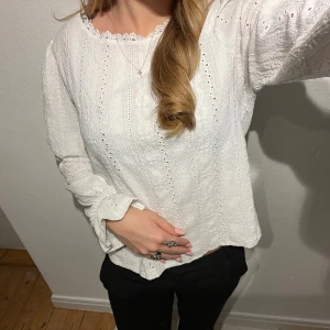 Vit blus med spetsdetaljer - Säljer en superfin vit blus med spetsdetaljer och långa ärmar. Perfekt för både vardag och fest! Den har en lös passform och är gjord i ett lätt och luftigt material. Passar perfekt till både jeans och kjol. 🕊️