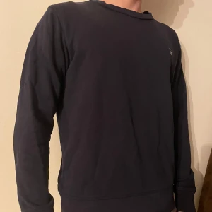 Mörkblå tröja från GANT - Säljer en jätte snygg tröja från GANT. Skicket är jätte bra och ser ut som ny. Perfekt för både vardag och lite finare tillfällen. Skriv om du har frågor!