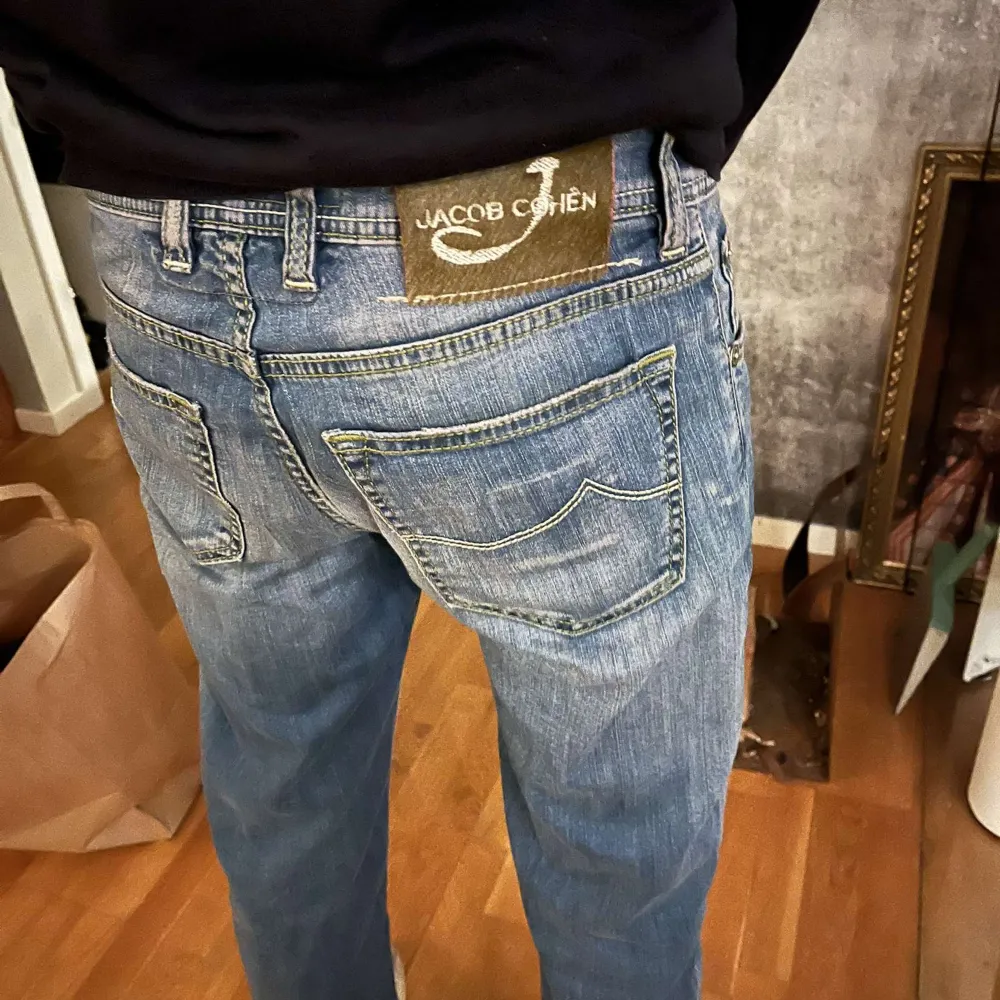 Säljer ett par snygga blå jeans från Jacob Cohën. De har en klassisk femficksdesign och knappar i gylfen. Jeansen är i bra skick och har en skön passform som passar perfekt till vardags. Model 622 slim, Storlek 30 men passar 31Märkeslappen på baksidan ger en exklusiv touch.. Jeans & Byxor.