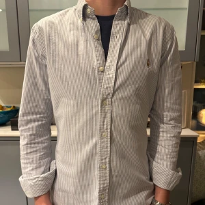 Randig skjorta från Polo Ralph Lauren - Säljer en stilren och klassisk randig skjorta från Polo Ralph Lauren. Skjortan är i bomull och har en snygg vit och blå färgkombination. Storlek S men passar till och med M🤩 Perfekt för både vardag och fest! 🕺