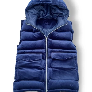 Mörkblå dunväst med huva - Säljer en snygg mörkblå dunväst i Manchester material med huva. Västen har en dragkedja framtill och två stora fickor. Perfekt för kyliga dagar och ger en stilren look. Passar bra till både vardag och fest. Den har aldrig använts och är därför i 10/10 skick, priset är ej hugget i sten så hör av er vid minsta fundering! Nypris 1399 kr!