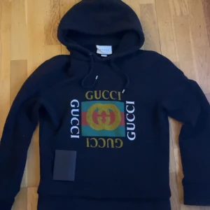Svart hoodie från Gucci - Säljer en snygg svart hoodie från Gucci med deras ikoniska logga i grönt, rött och gult på framsidan. Den är väldigt Unik och eftertraktad, Kvittot ingår såklart också, Storlek S men passar även M