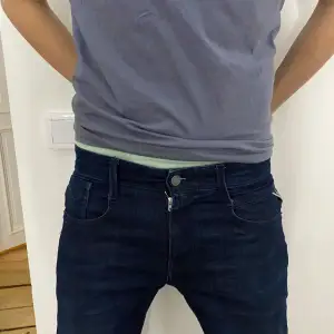 Säljer ett par snygga mörkblå jeans från Replay, modell Anbass. De har en slim fit och är i mycket bra skick. Perfekta för både vardag och fest! 🕺